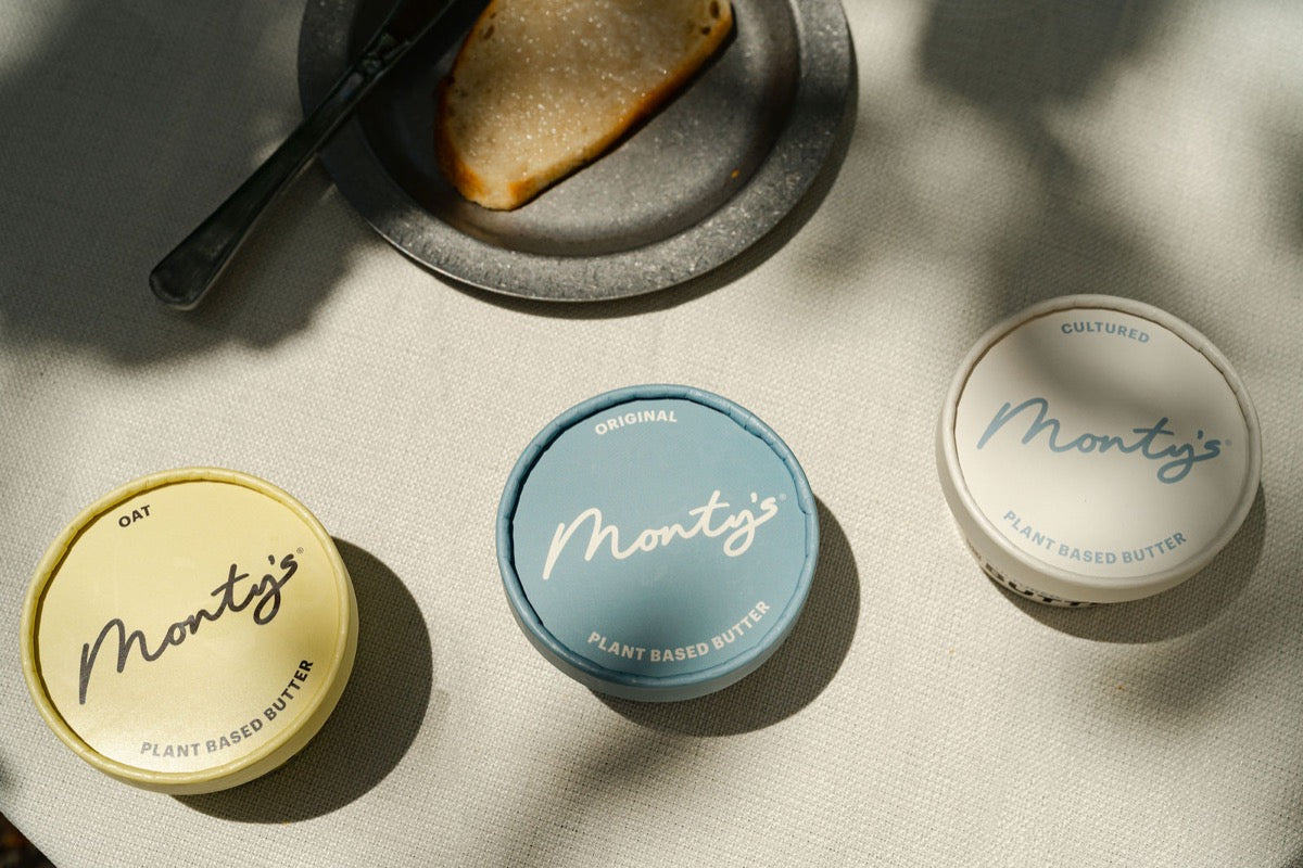 Monty's Oat, Original, and Cultured butter cups side by side on a sunlit table